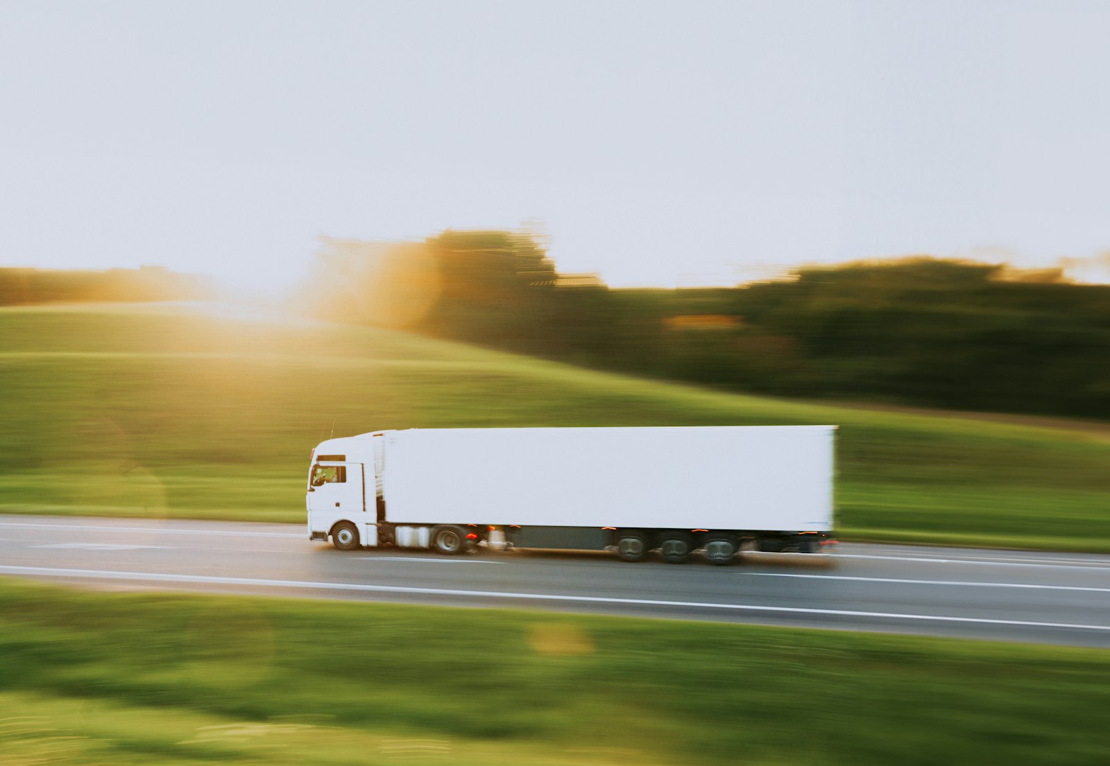 Freight truck travelling on a highway at sunset