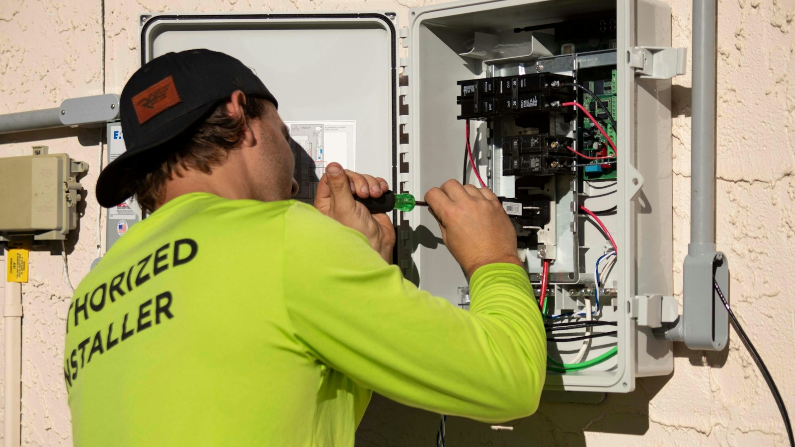 Electrician installing and wiring an electrical panel on site